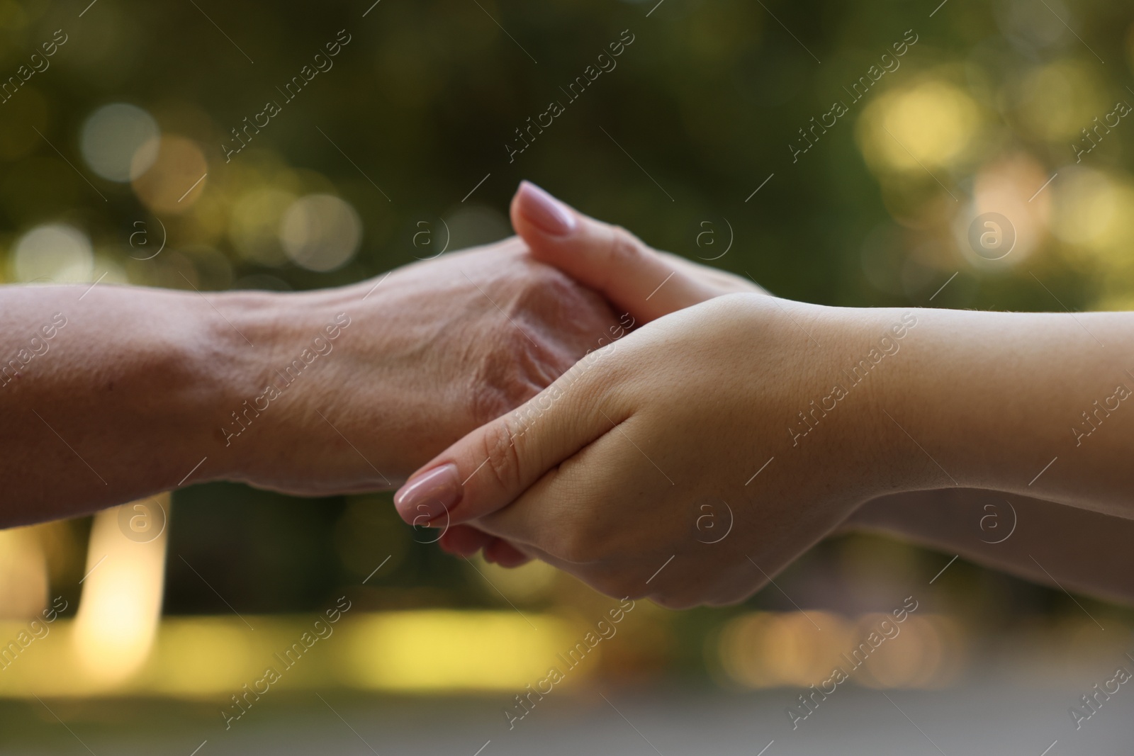 Photo of Trust and support. Women joining hands outdoors, closeup