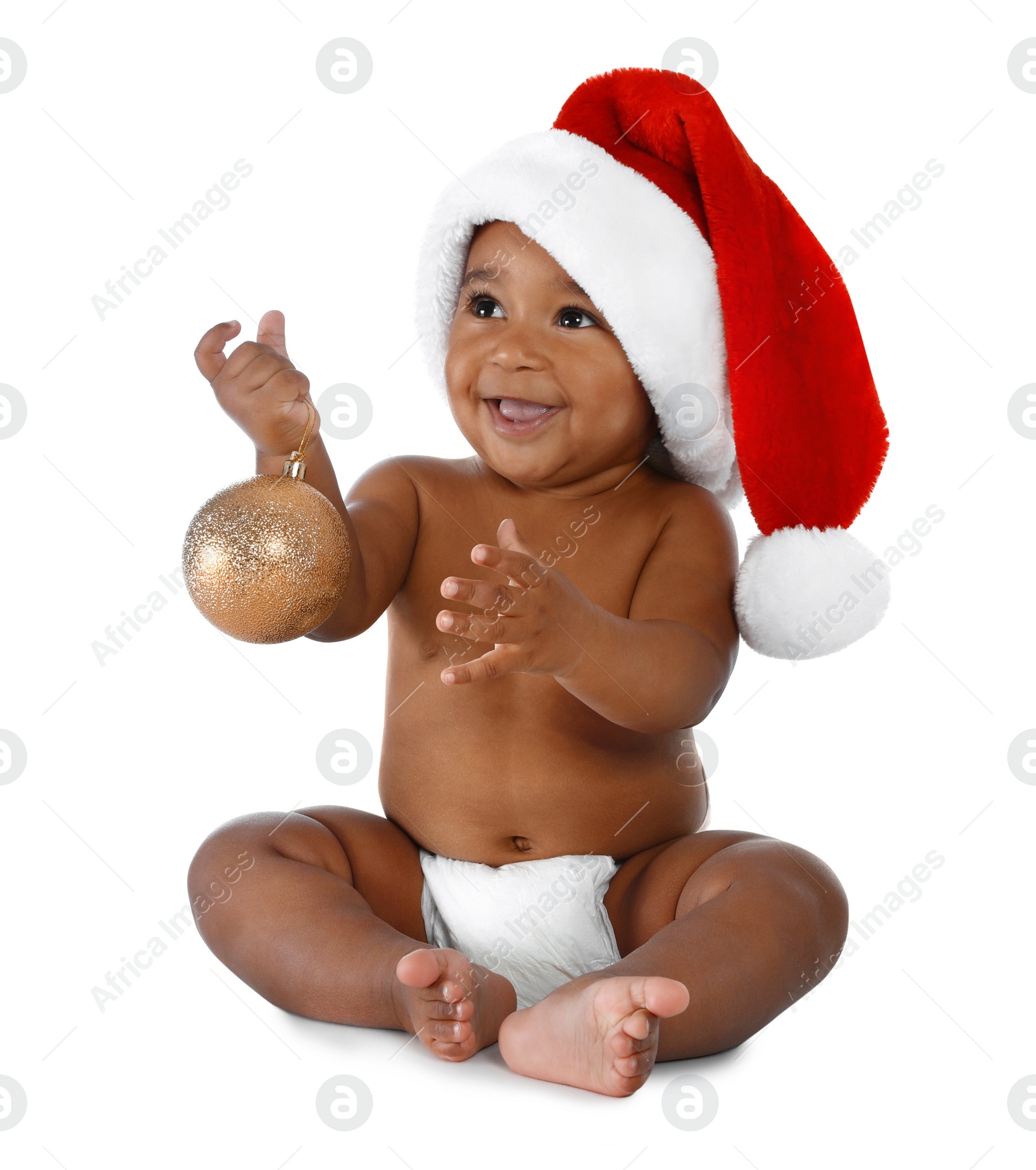 Photo of Cute African-American baby wearing Santa hat with Christmas decoration on white background