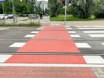 Road crossing with red bicycle lane in city