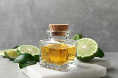 Photo of Bottle of bergamot essential oil on grey table