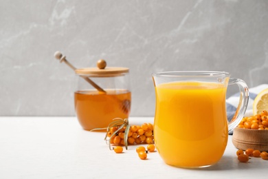 Photo of Fresh sea buckthorn tea on white wooden table