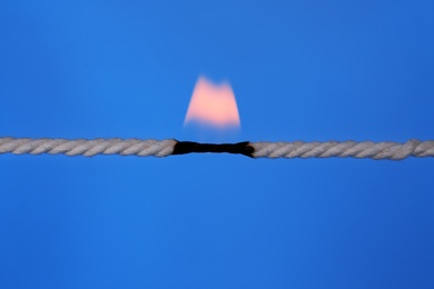 Photo of Burning rope at breaking point on color background