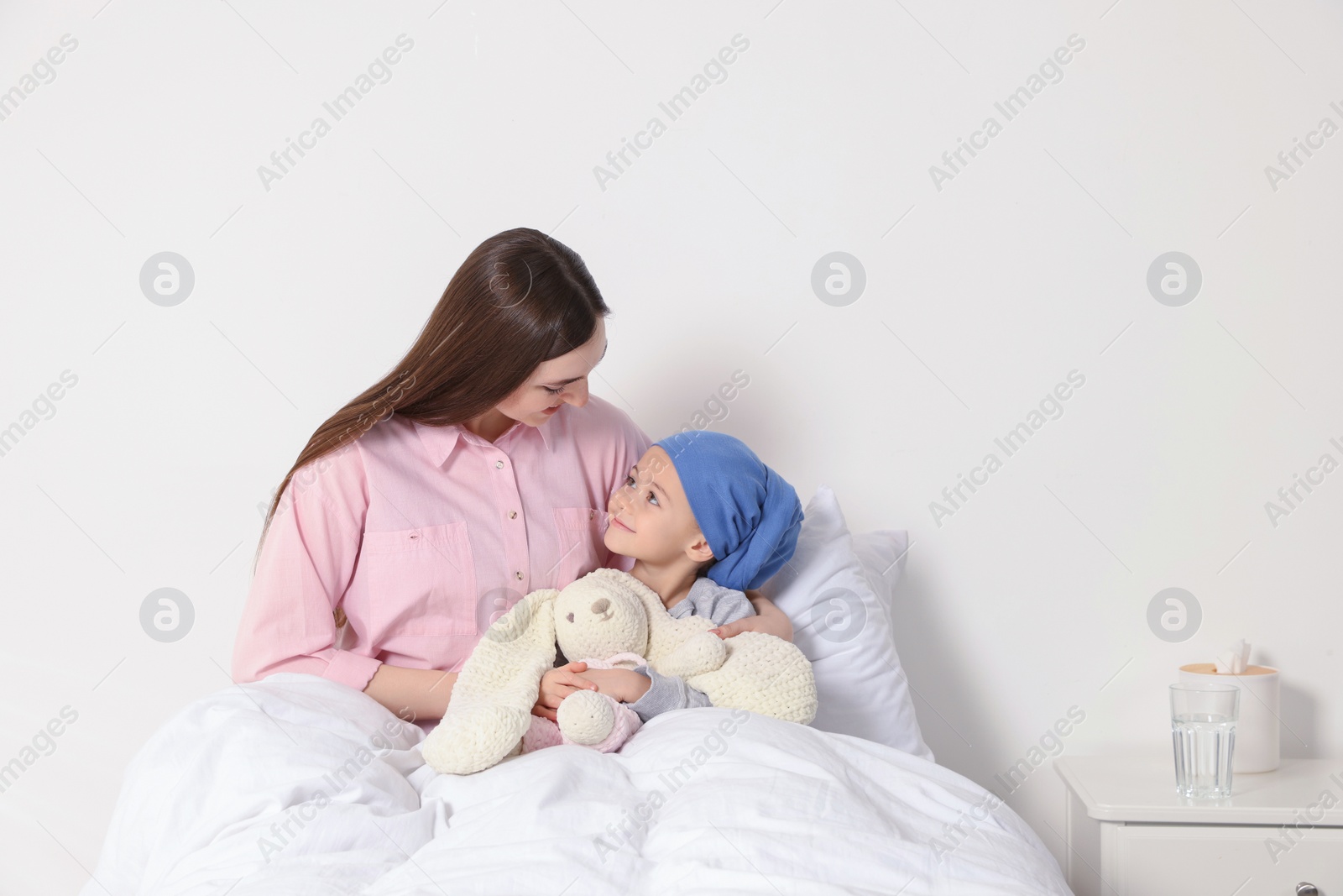 Photo of Childhood cancer. Mother and daughter with toy bunny in hospital