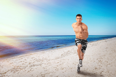 Image of Athletic young man running near sea on sunny day, space for text 