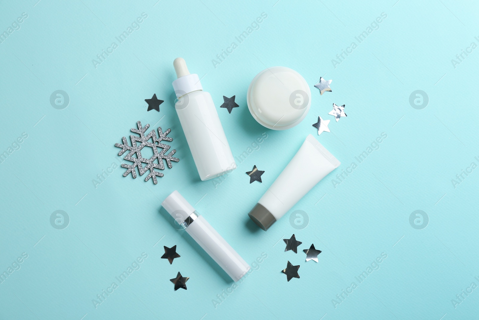 Photo of Flat lay composition with different cosmetic products on turquoise background. Winter care