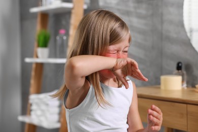Photo of Suffering from allergy. Little girl sneezing in bathroom