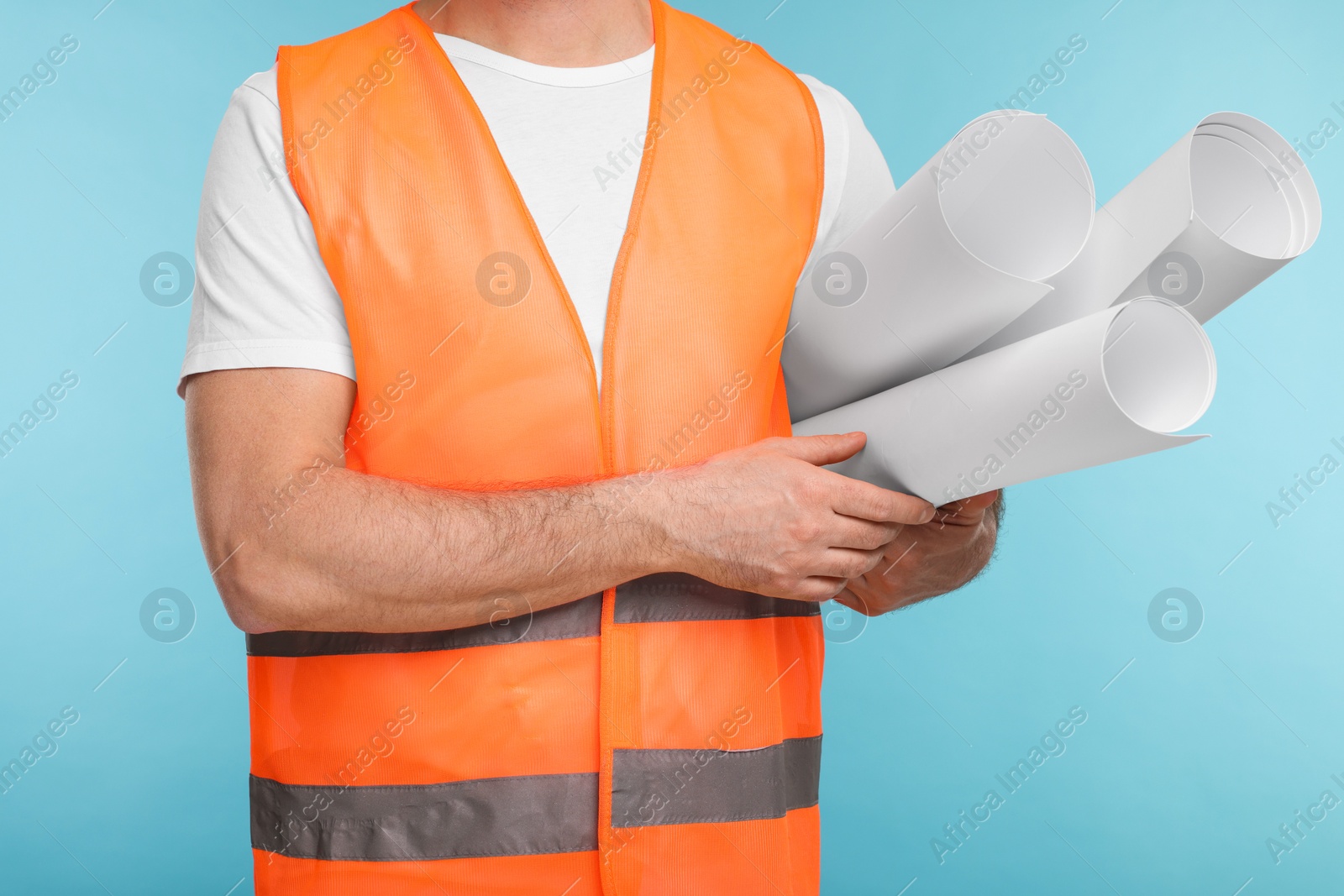 Photo of Architect with drafts on light blue background, closeup