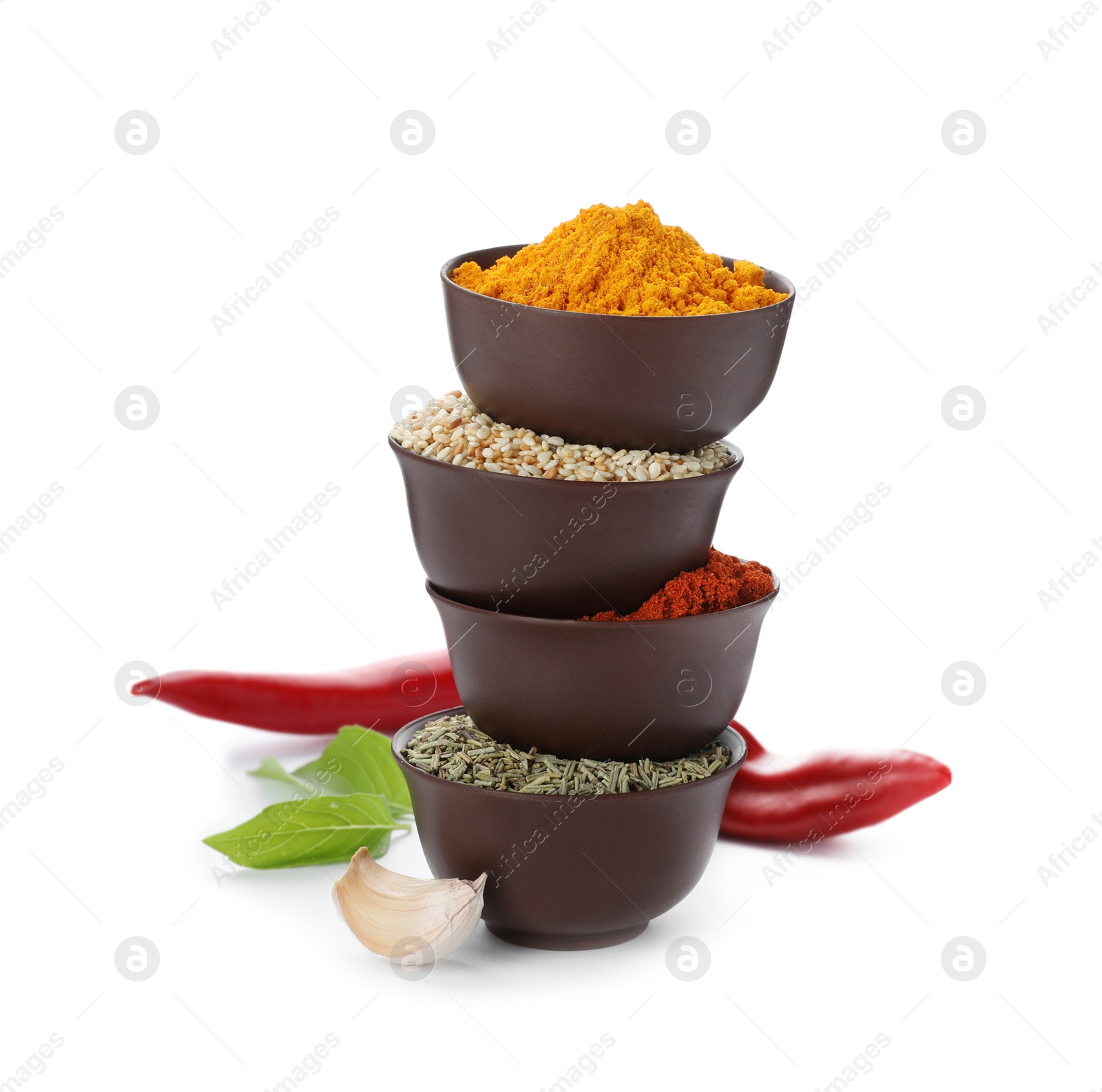 Photo of Stack of bowls with different aromatic spices on white background