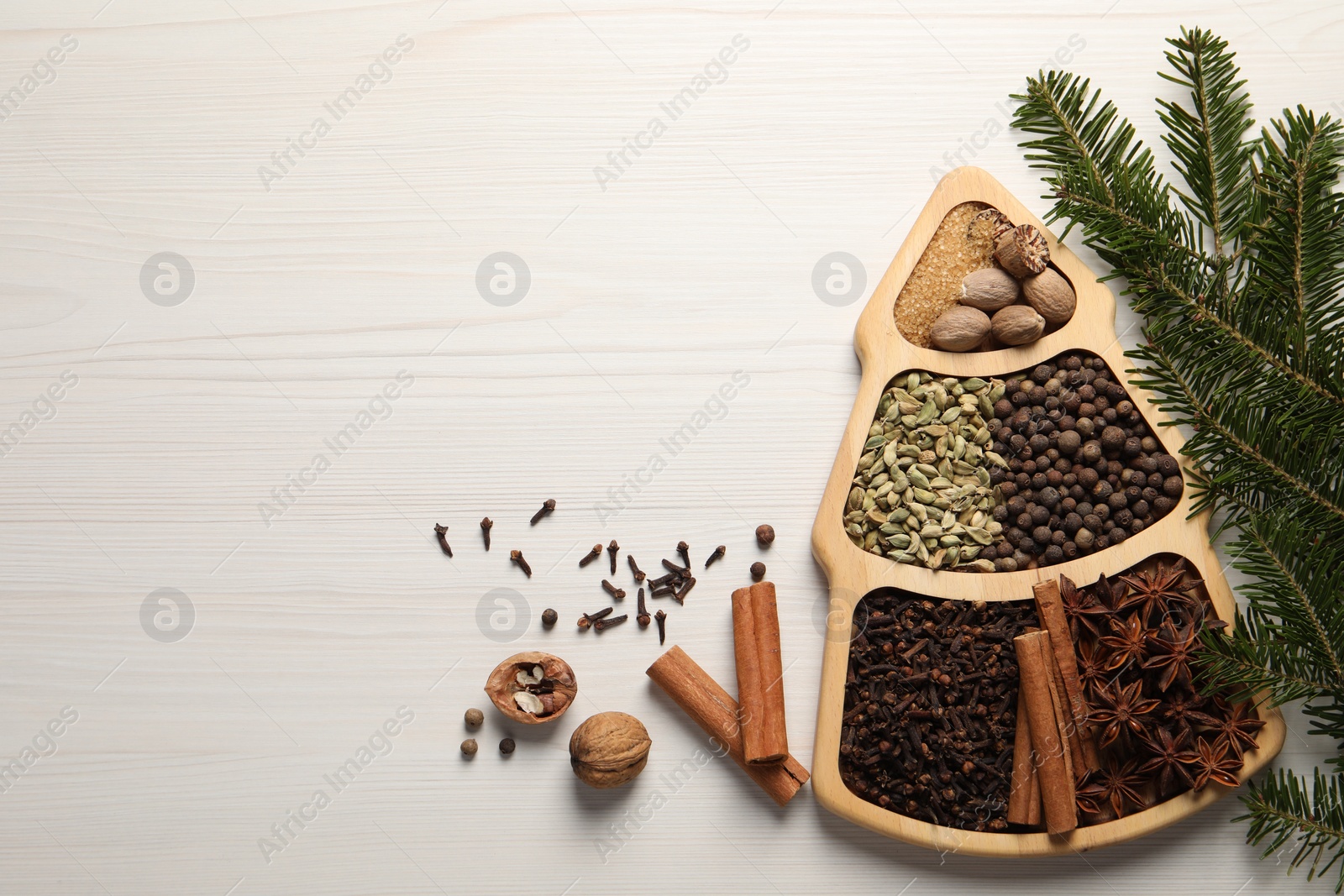 Photo of Different spices, nuts and fir branches on white wooden table, flat lay. Space for text