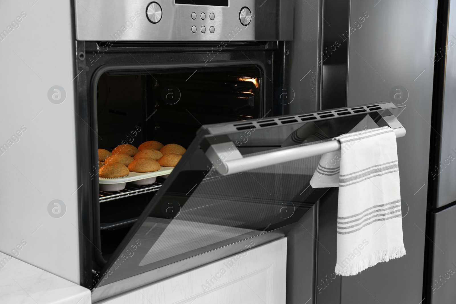 Photo of Baking pan with cupcakes in modern oven