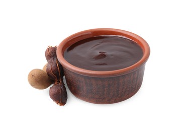 Photo of Bowl of tamarind sauce and fresh pods isolated on white