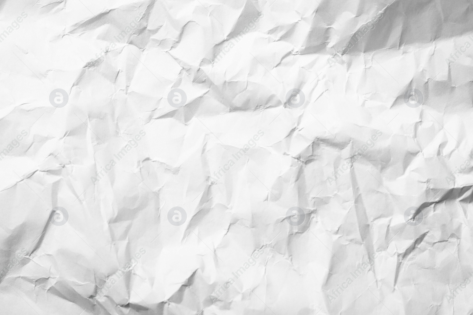 Photo of Sheet of white crumpled paper as background, closeup