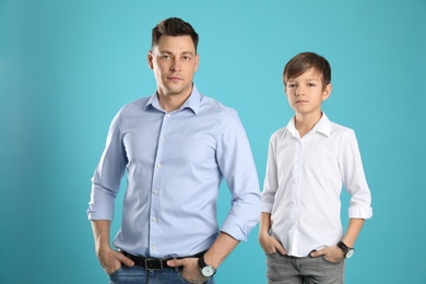 Portrait of dad and his son on color background