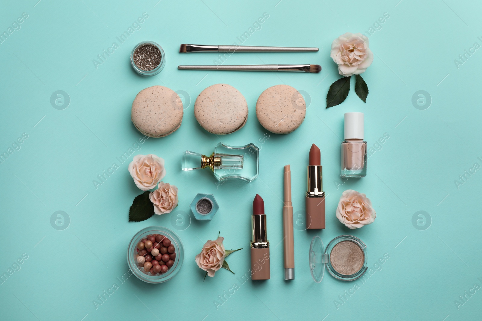 Photo of Flat lay composition with makeup products, roses and macarons on turquoise background