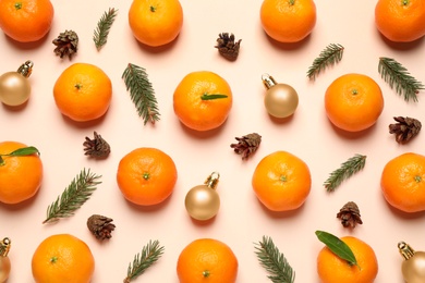 Photo of Composition with Christmas balls and tangerines on beige background, flat lay