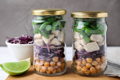 Photo of Glass jars with healthy meal on wooden table