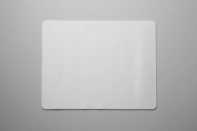 One mouse pad on grey background, top view. Space for text