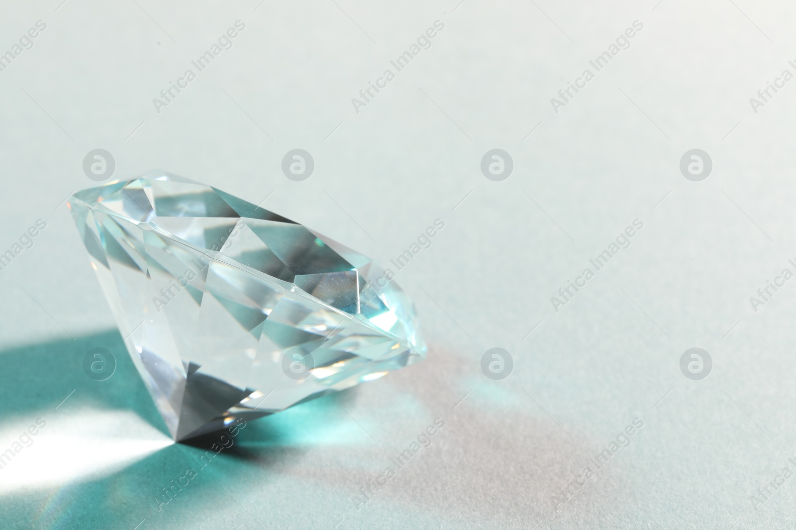 Photo of Beautiful dazzling diamond on white background. Space for text