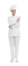 Happy woman chef in uniform pointing at something on white background