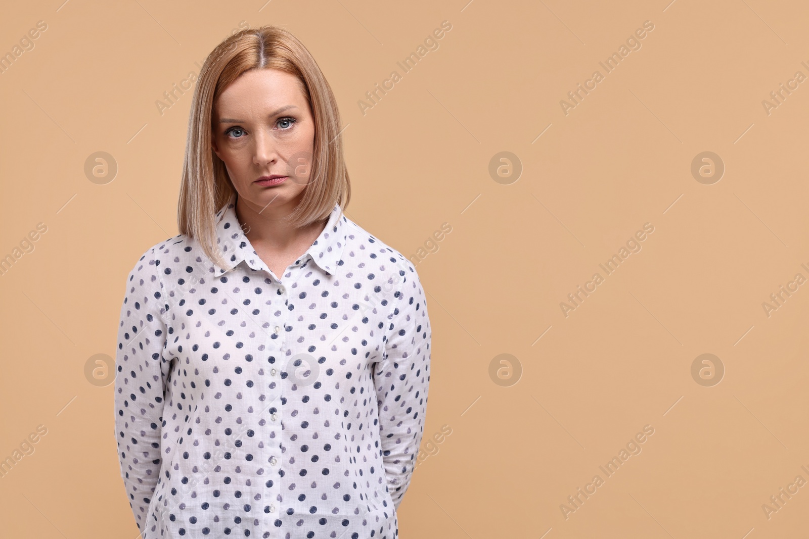 Photo of Portrait of sad woman on beige background. Space for text