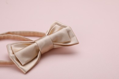 Photo of Stylish bow tie on beige background, closeup. Space for text