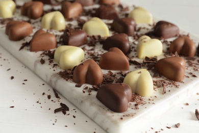 Photo of Beautiful heart shaped chocolate candies on white table