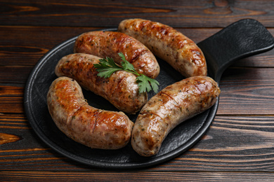Photo of Delicious fresh grilled sausages on wooden table