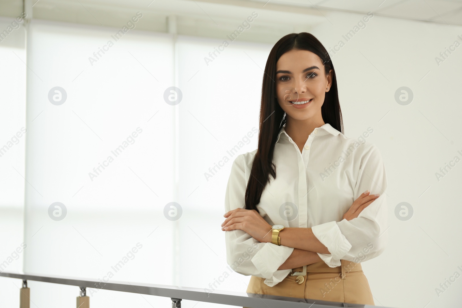 Photo of Happy young businesswoman leaning on railing in office. Space for text