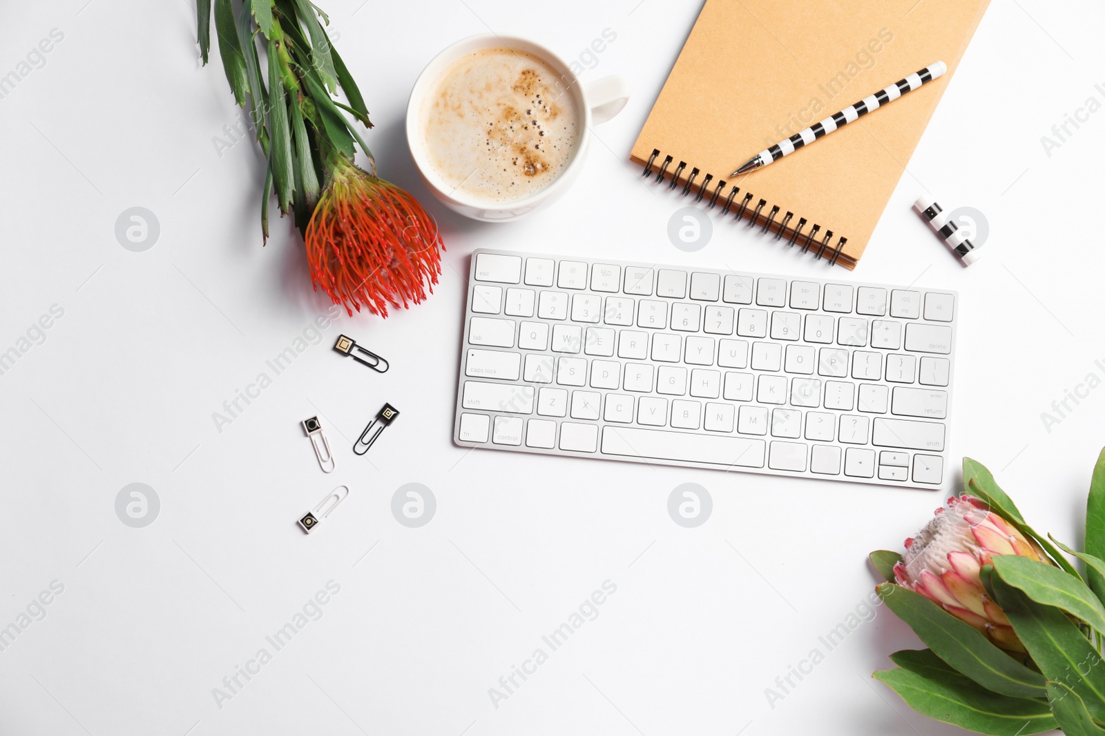 Photo of Creative flat lay composition with tropical flowers, stationery and computer keyboard on white background