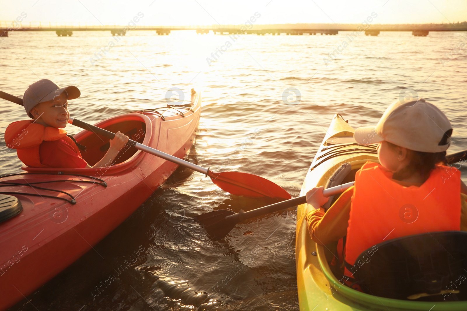 Photo of Little children kayaking on river. Summer camp activity