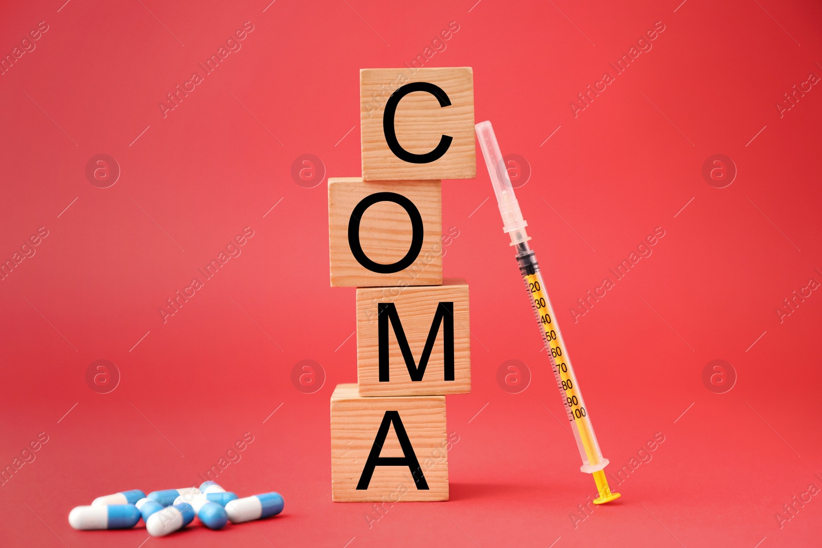 Photo of Wooden cubes with word Coma, syringe and pills on red background