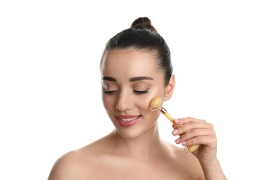 Woman using natural jade face roller on white background