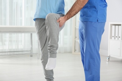 Photo of Doctor working with patient in hospital, closeup. Rehabilitation exercises