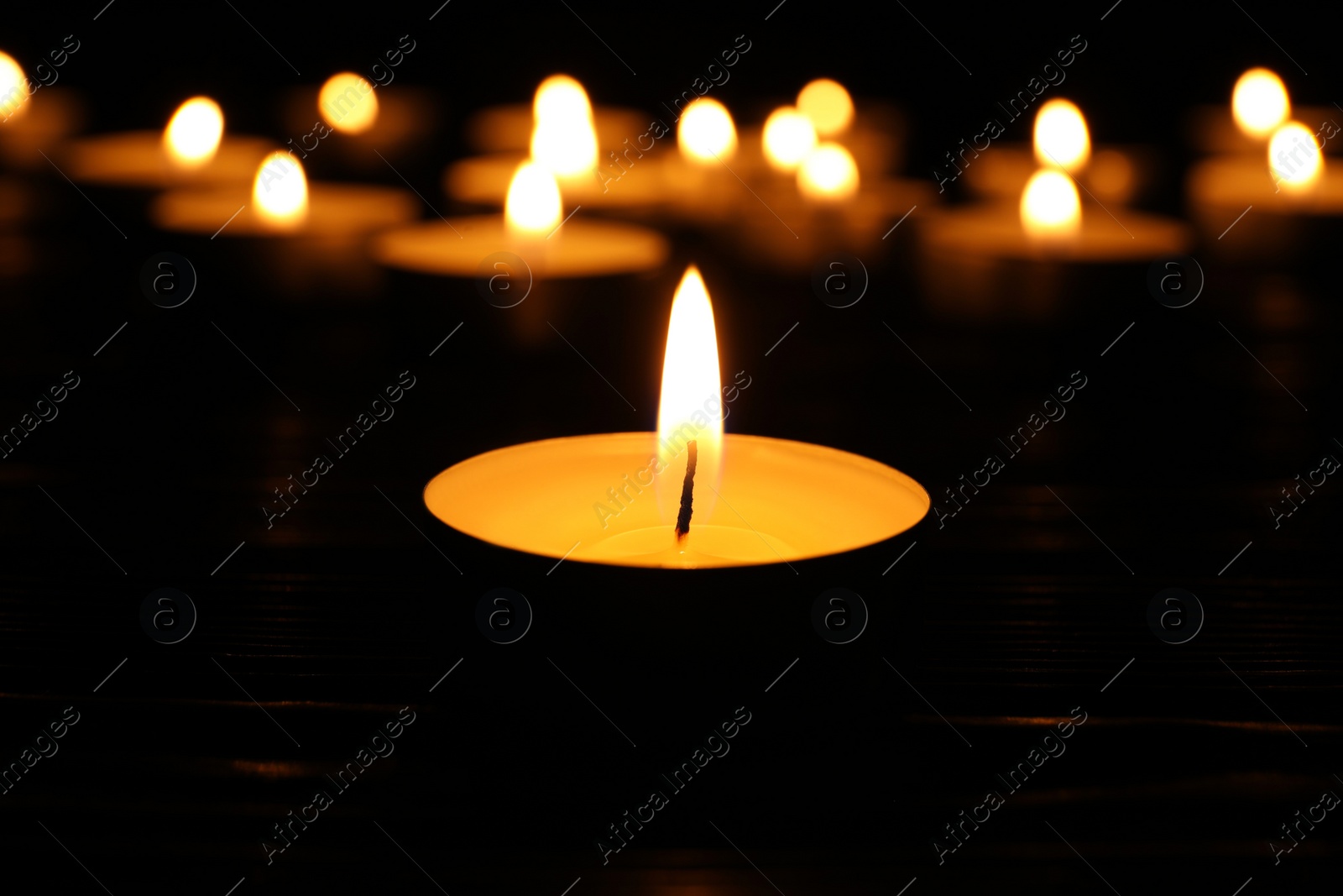 Photo of Burning candle in darkness, closeup. Memory day