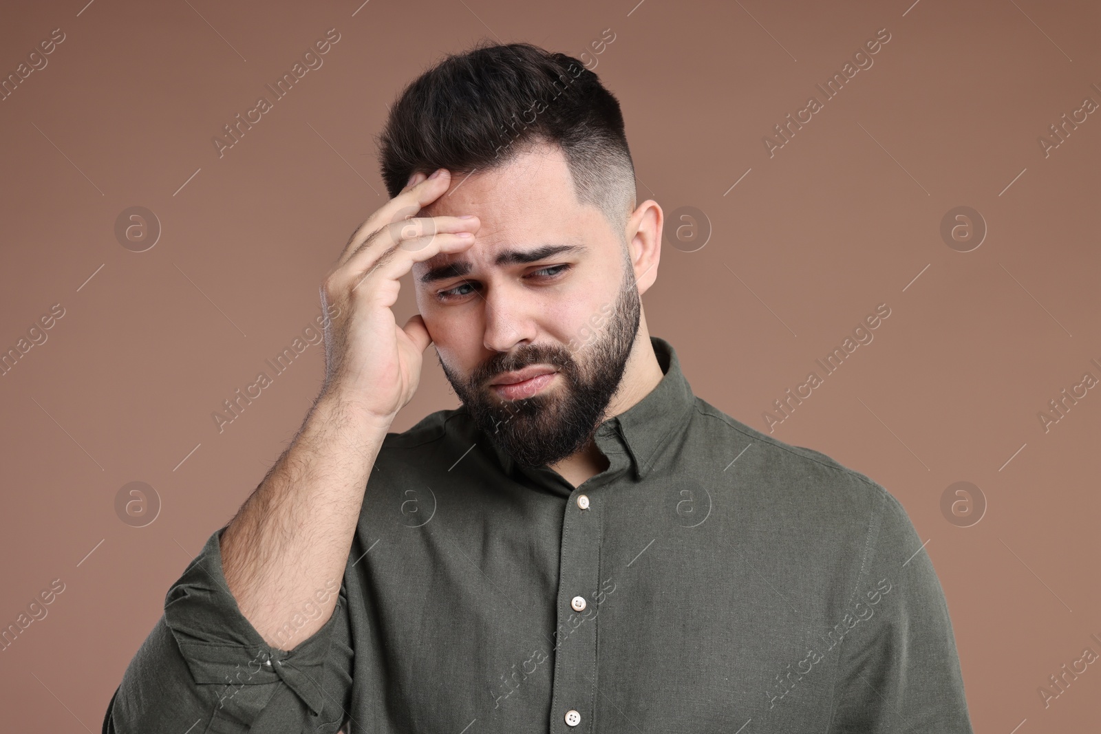 Photo of Portrait of sad man on brown background