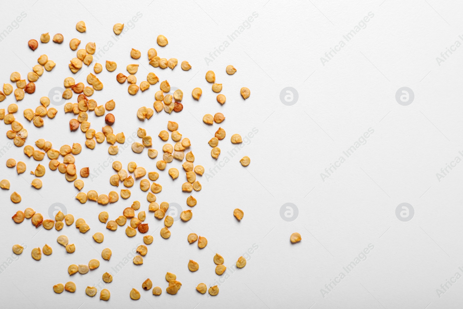 Photo of Many pepper seeds on white background, top view