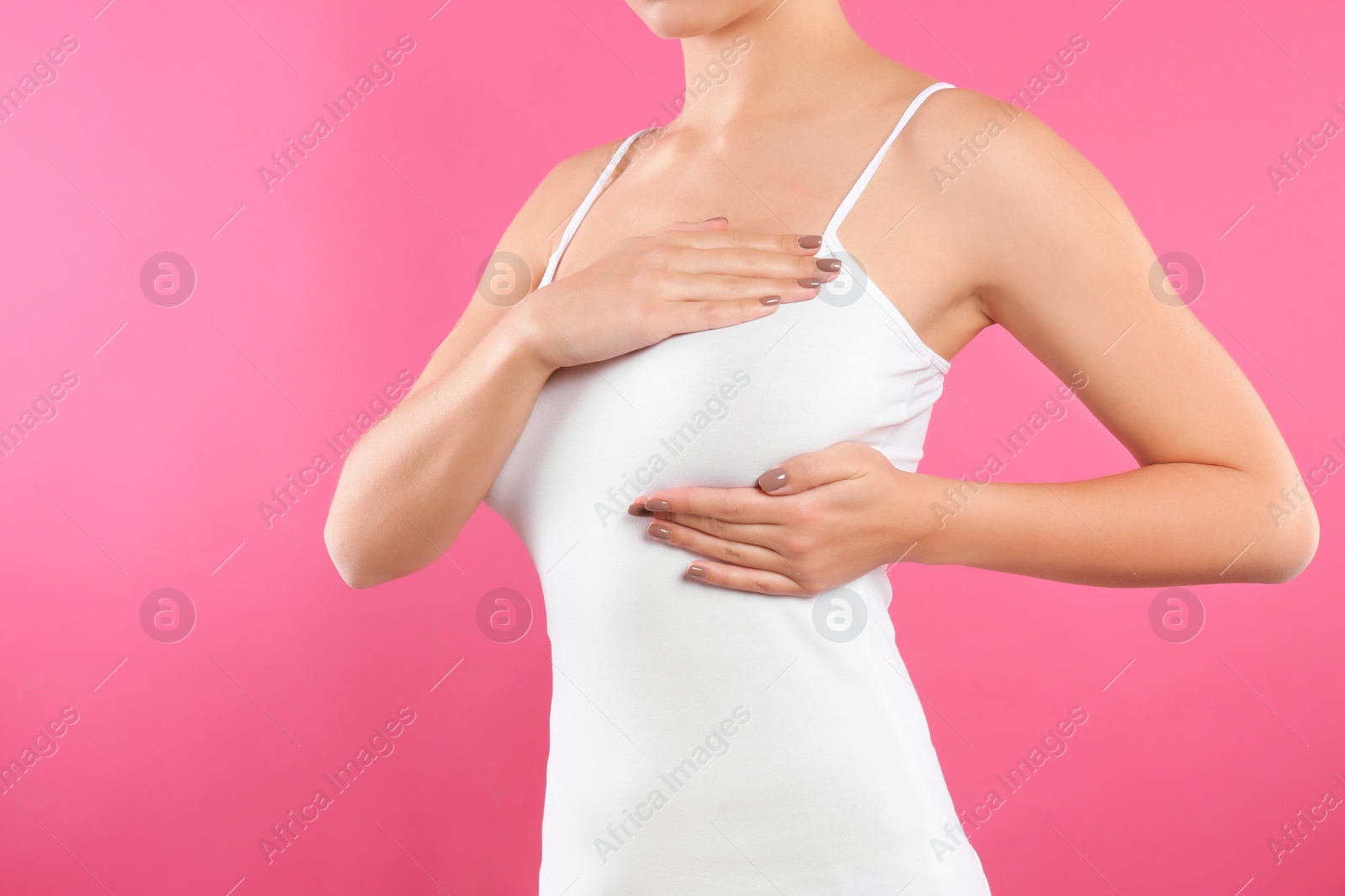 Photo of Woman checking her breast on color background, closeup