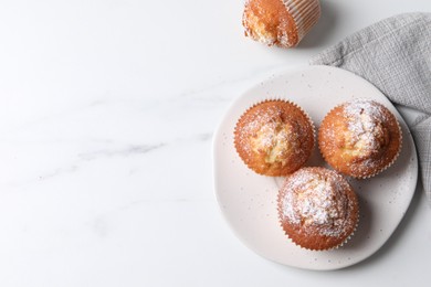 Delicious sweet muffins on white marble table, flat lay. Space for text