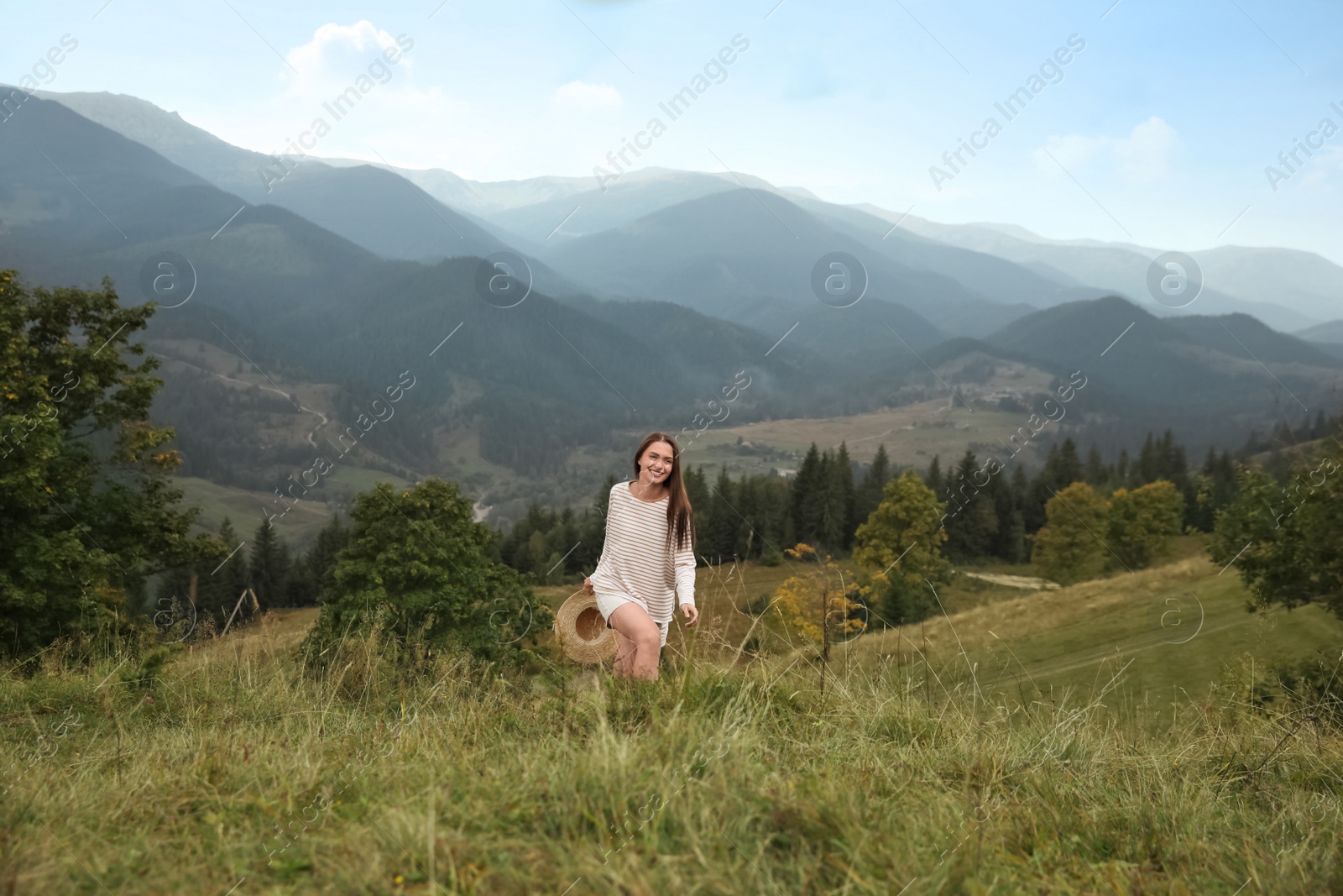 Photo of Young woman with stylish hat enjoying her time in mountains