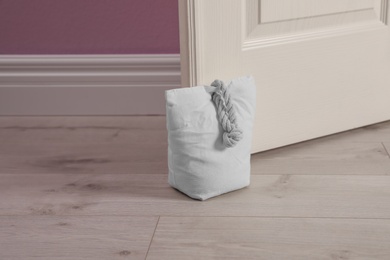 Photo of Stuffed bag holding wooden door at home