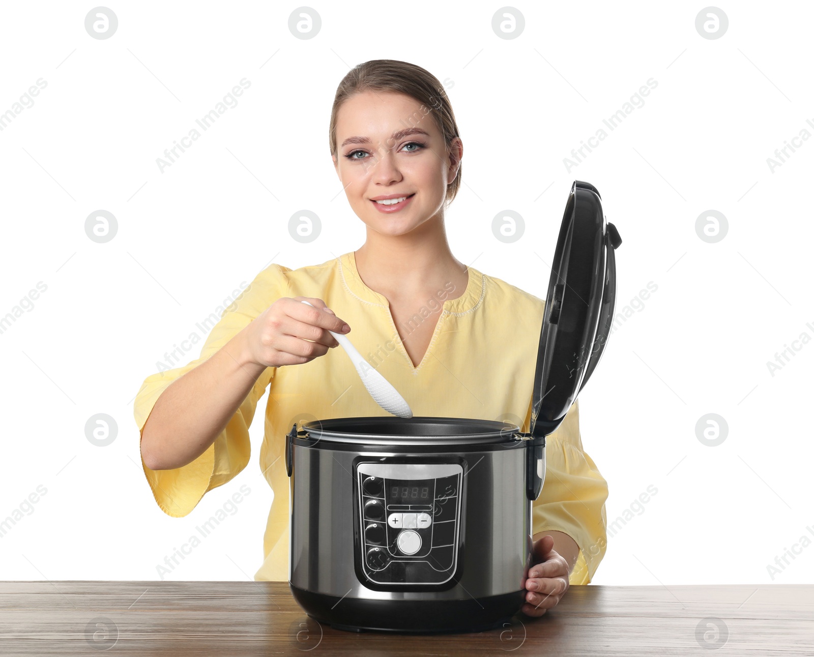 Photo of Young woman preparing food with modern multi cooker at table against white background