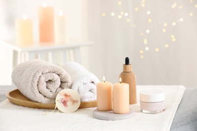 Photo of Spa composition. Burning candles and personal care products on soft surface