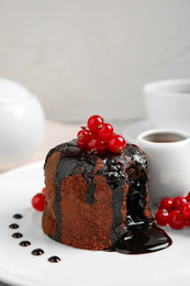 Photo of Delicious warm chocolate lava cake with berries on plate, closeup