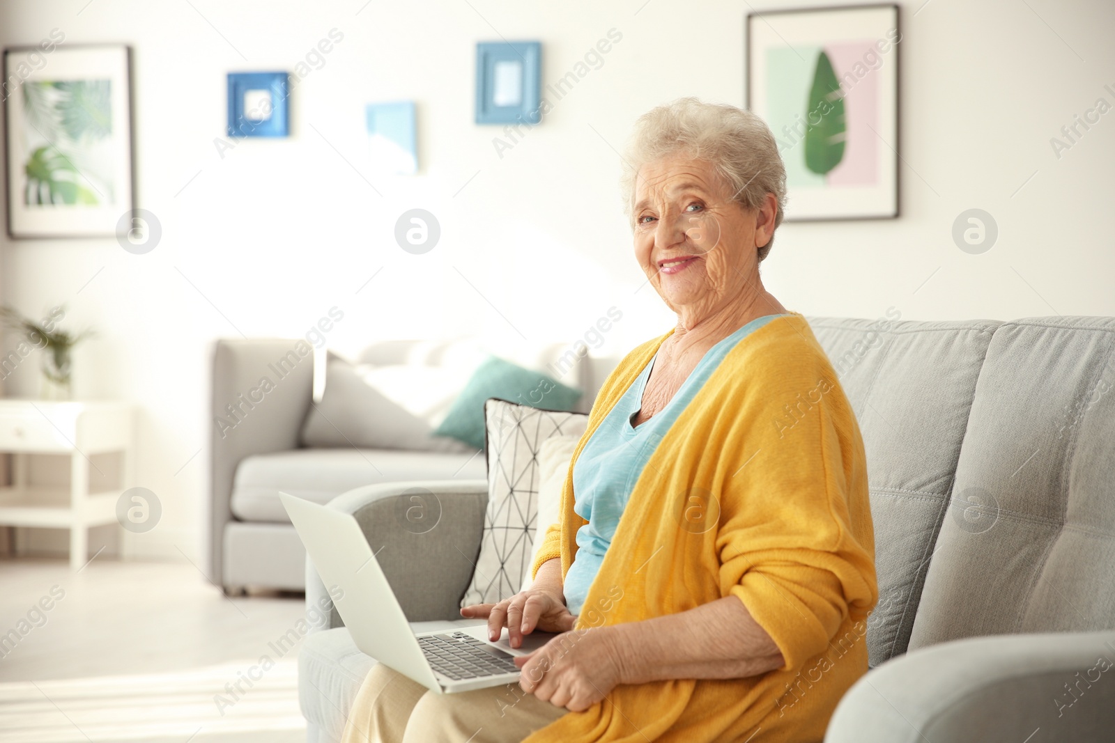 Photo of Elderly woman using laptop in living room