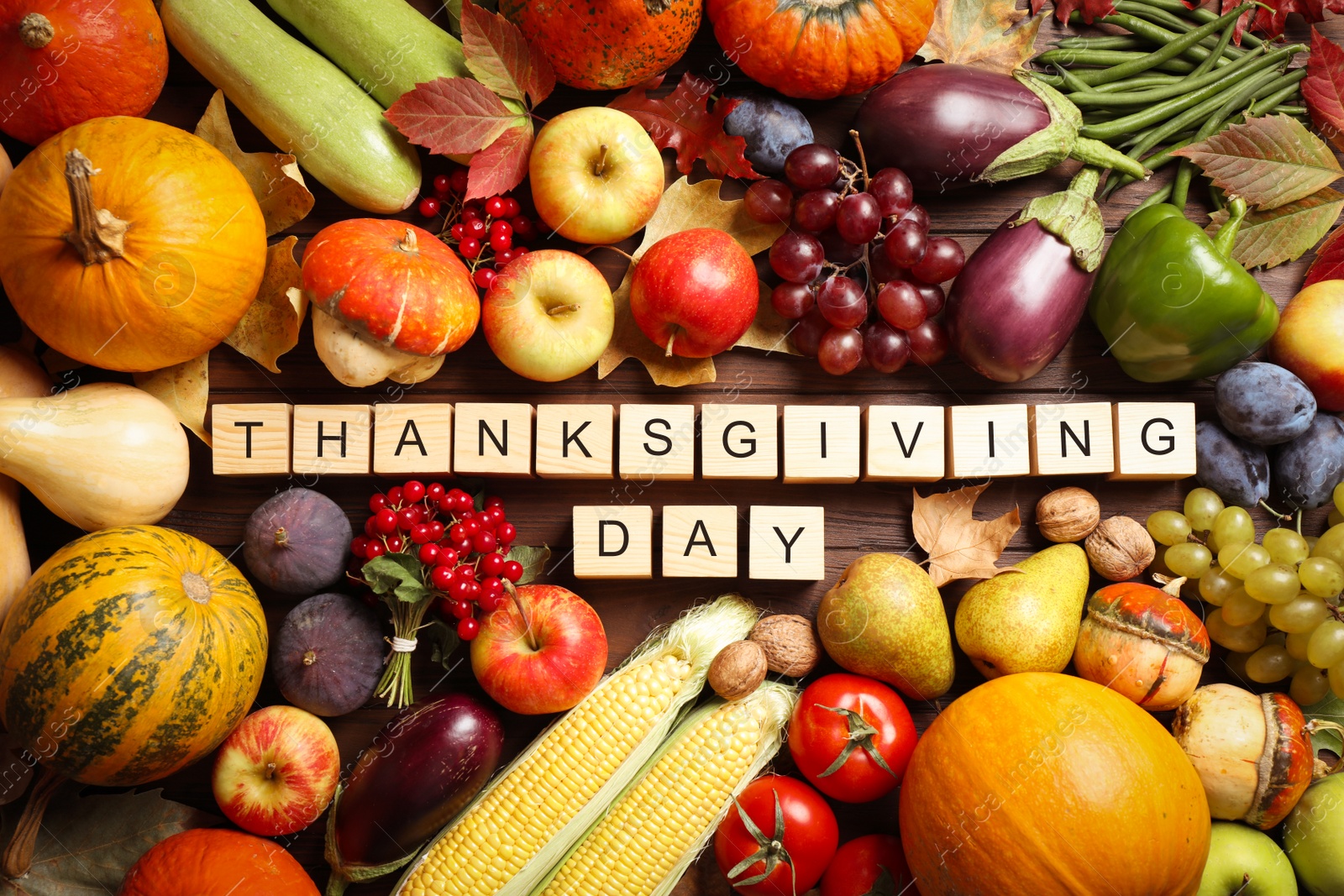 Photo of Cubes with phrase THANKSGIVING DAY, autumn fruits and vegetables on wooden background, flat lay. Happy holiday