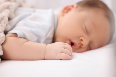 Cute newborn baby sleeping on white bed, selective focus