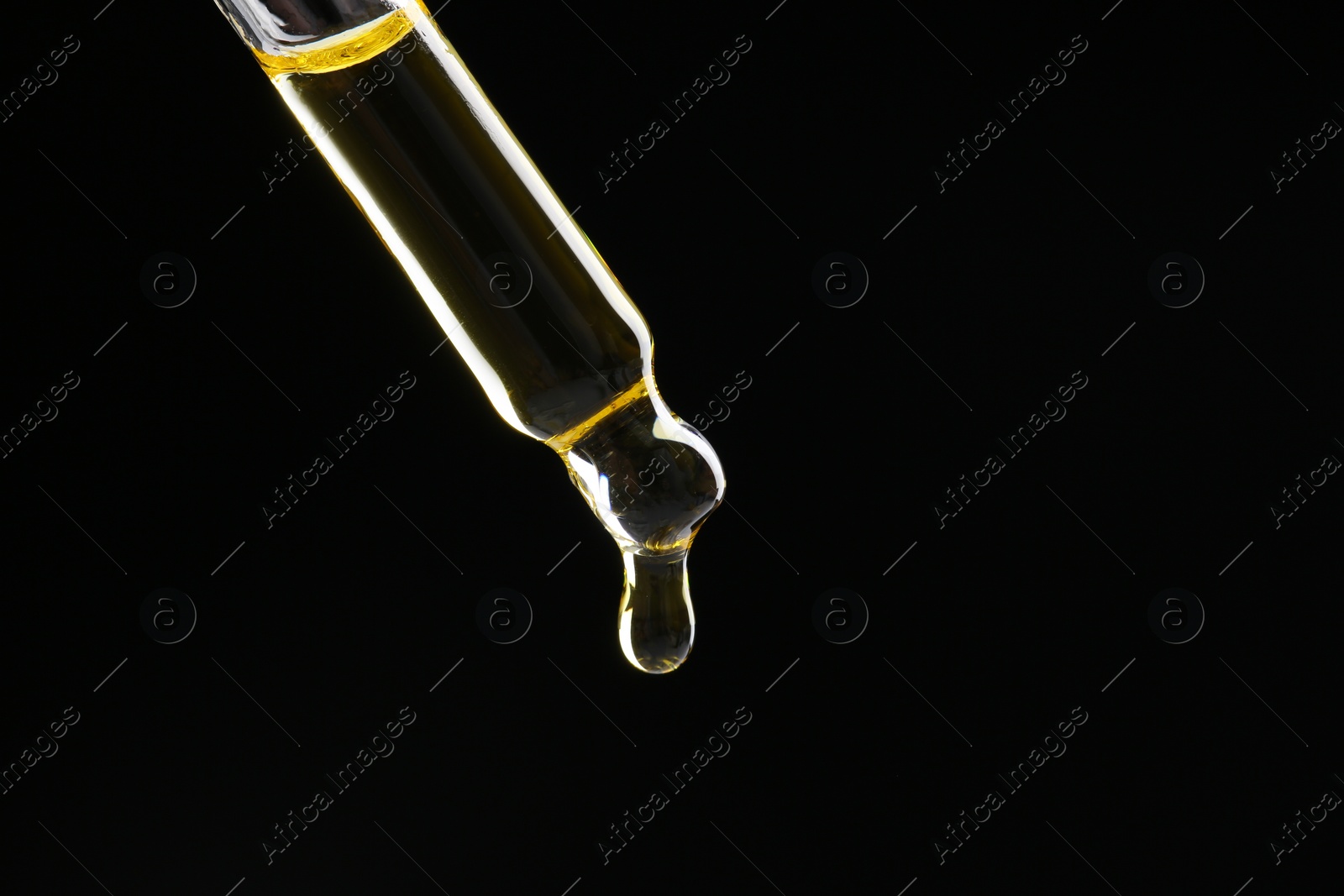 Photo of Dripping tincture from pipette on black background, closeup. Space for text