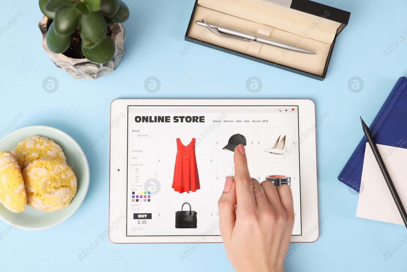 Photo of Woman with tablet shopping online on light blue background, top view