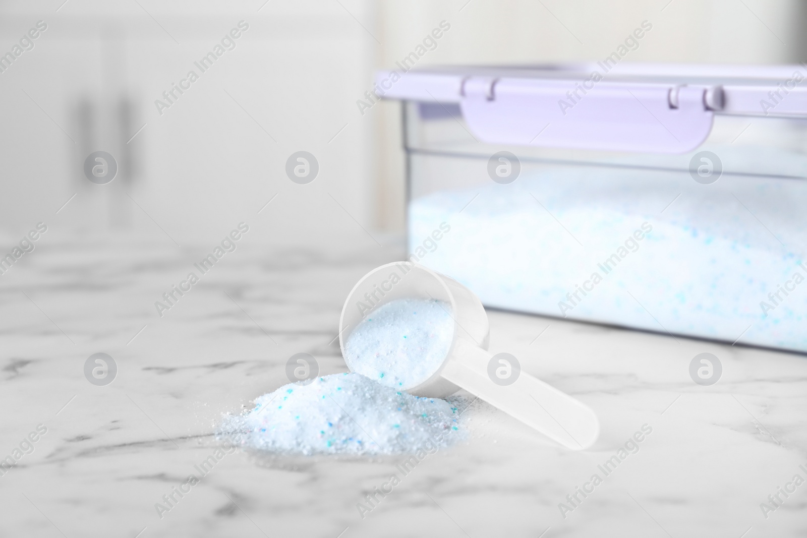 Photo of Measuring scoop with laundry powder near container on table. Space for text