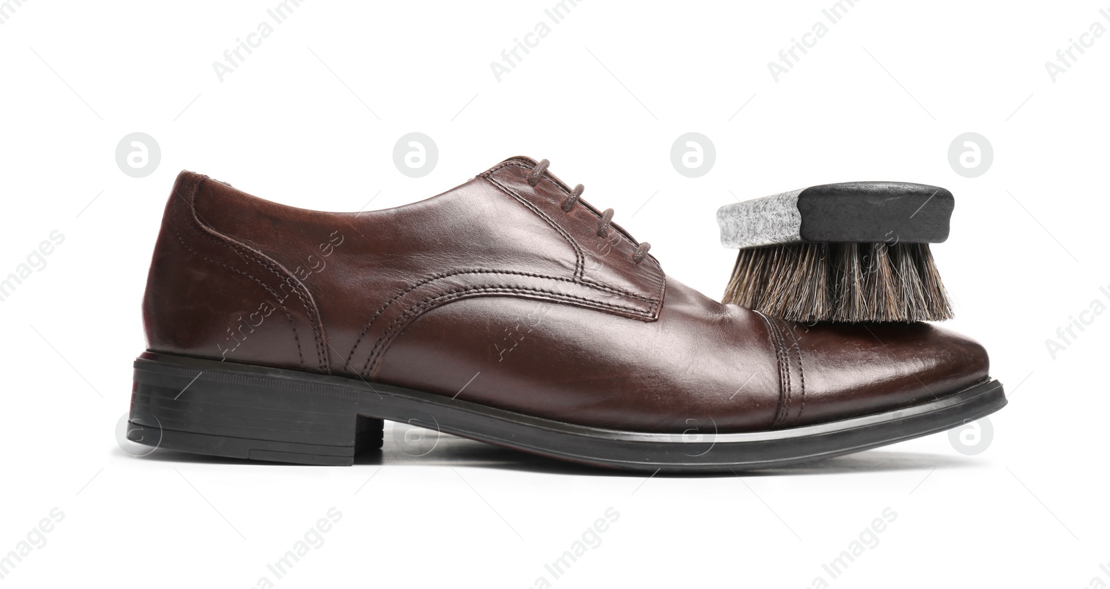 Photo of Stylish men's shoe and cleaning brush on white background